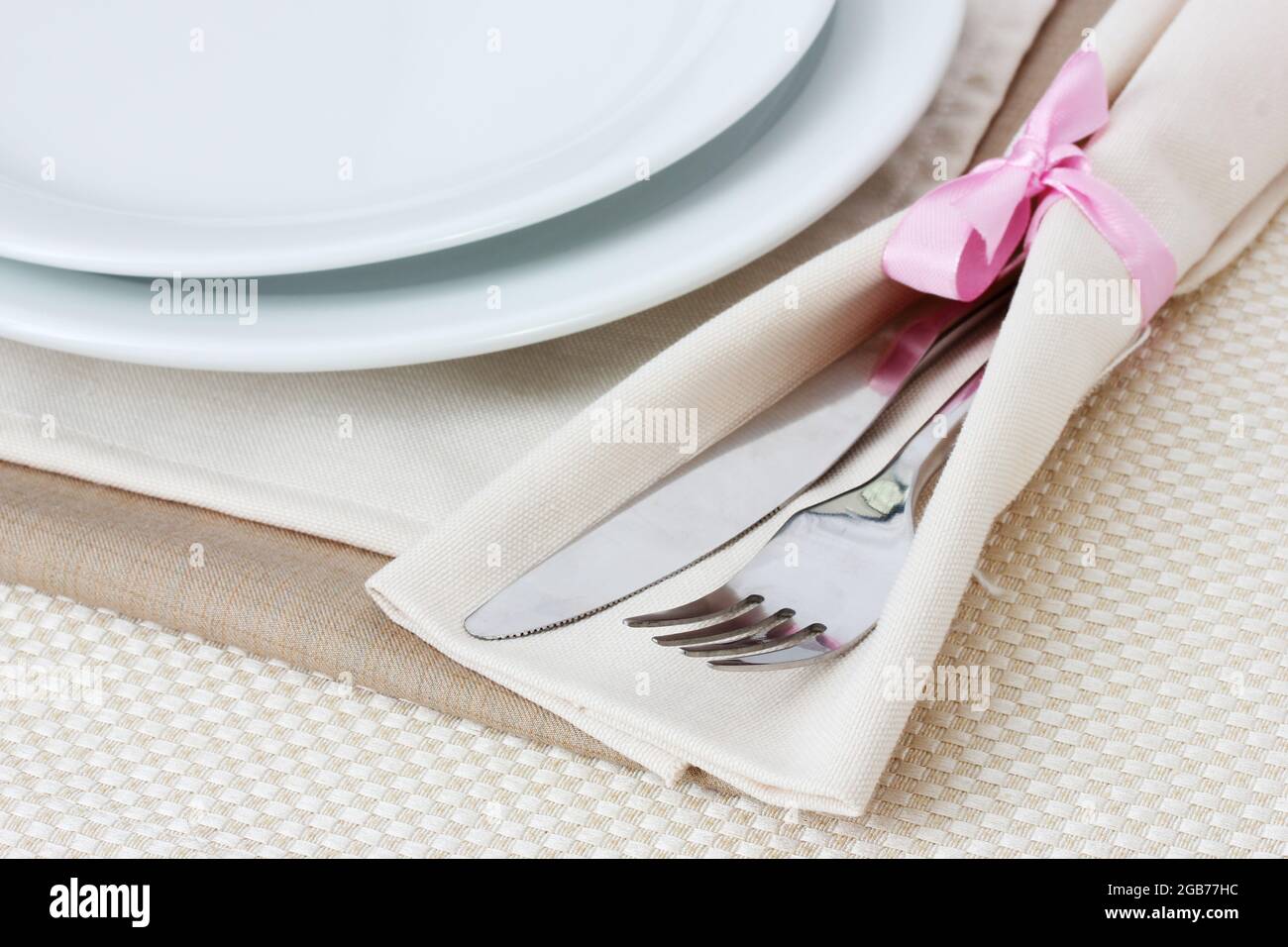 Table setting with fork, knife, plates, and napkin Stock Photo Alamy