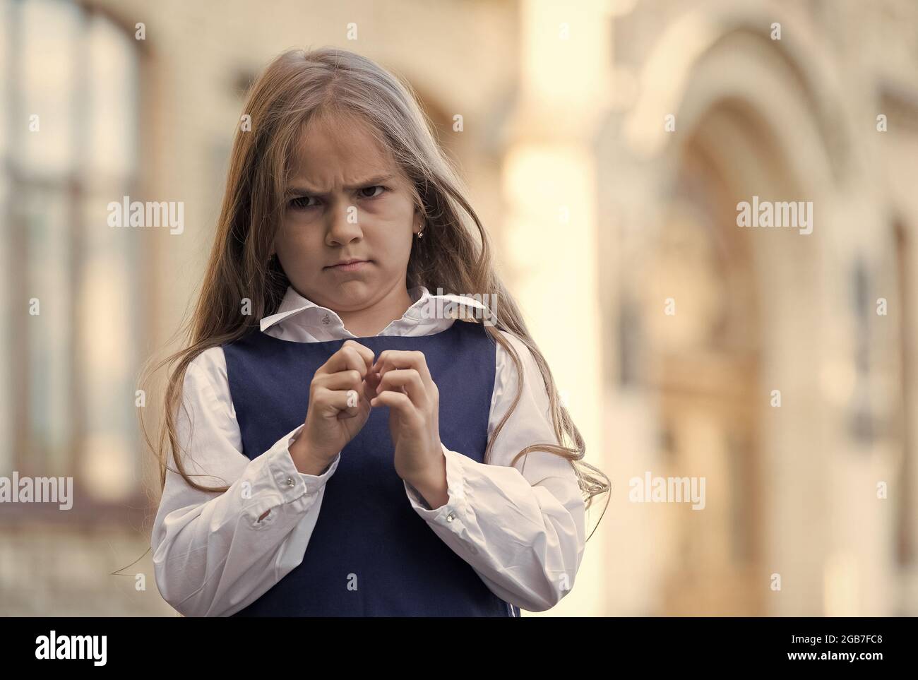 I hate school. Naughty girl child. Unhappy girl back to school. Wearing fashion uniform. Formal education. September 1. Knowledge day. Feeling dread Stock Photo