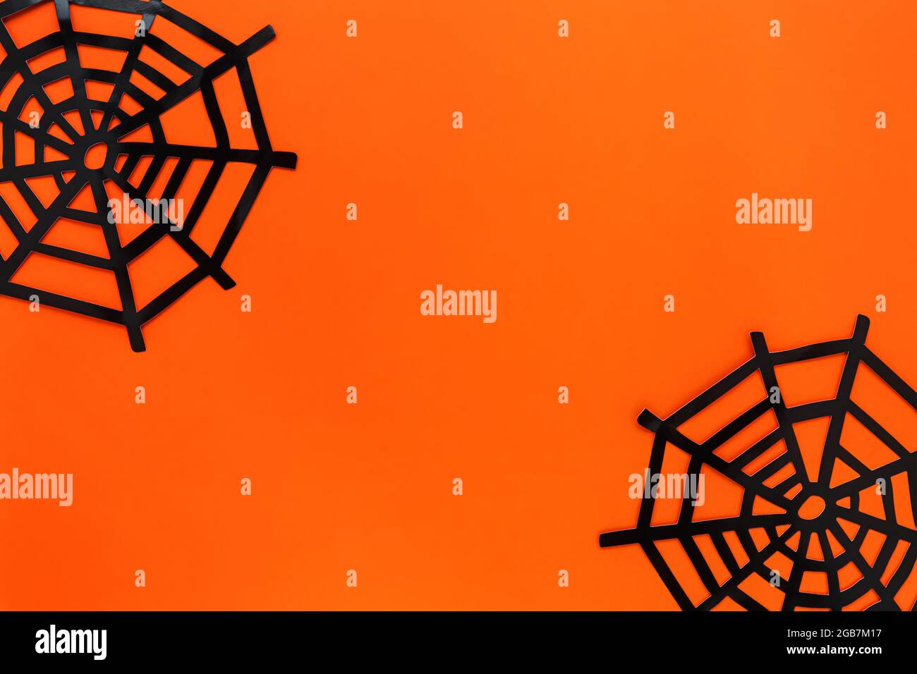 Halloween festive concept. Decorative spider net on a bright orange