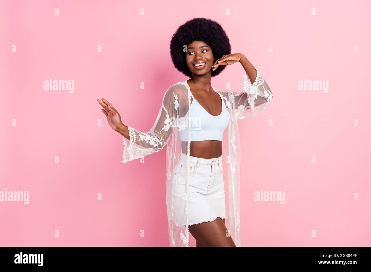 Photo of dreamy happy young dark skin woman look empty space dance isolated on pink color background Stock Photo
