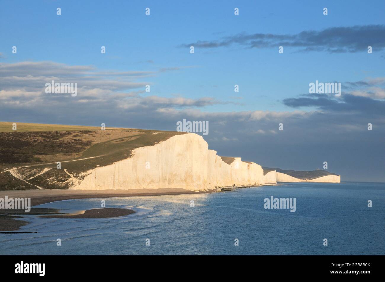 Early evening sunlight bathes the famous Seven Sisters chalk cliffs on the south coast of England, between Seaford and Eastbourne, East Sussex, UK Stock Photo
