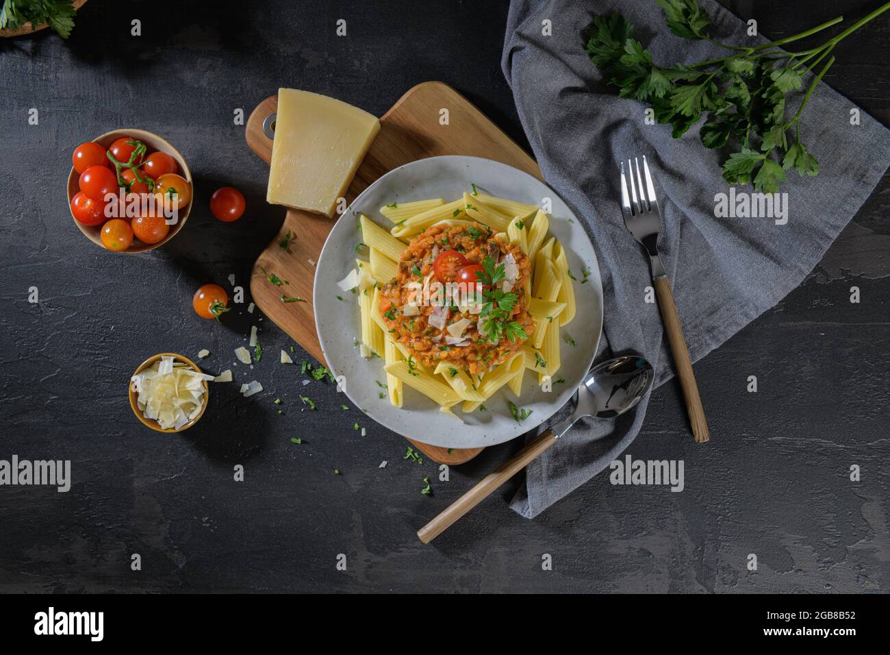 Vegetarian lentil Bolognese sauce penne pasta on a dark background