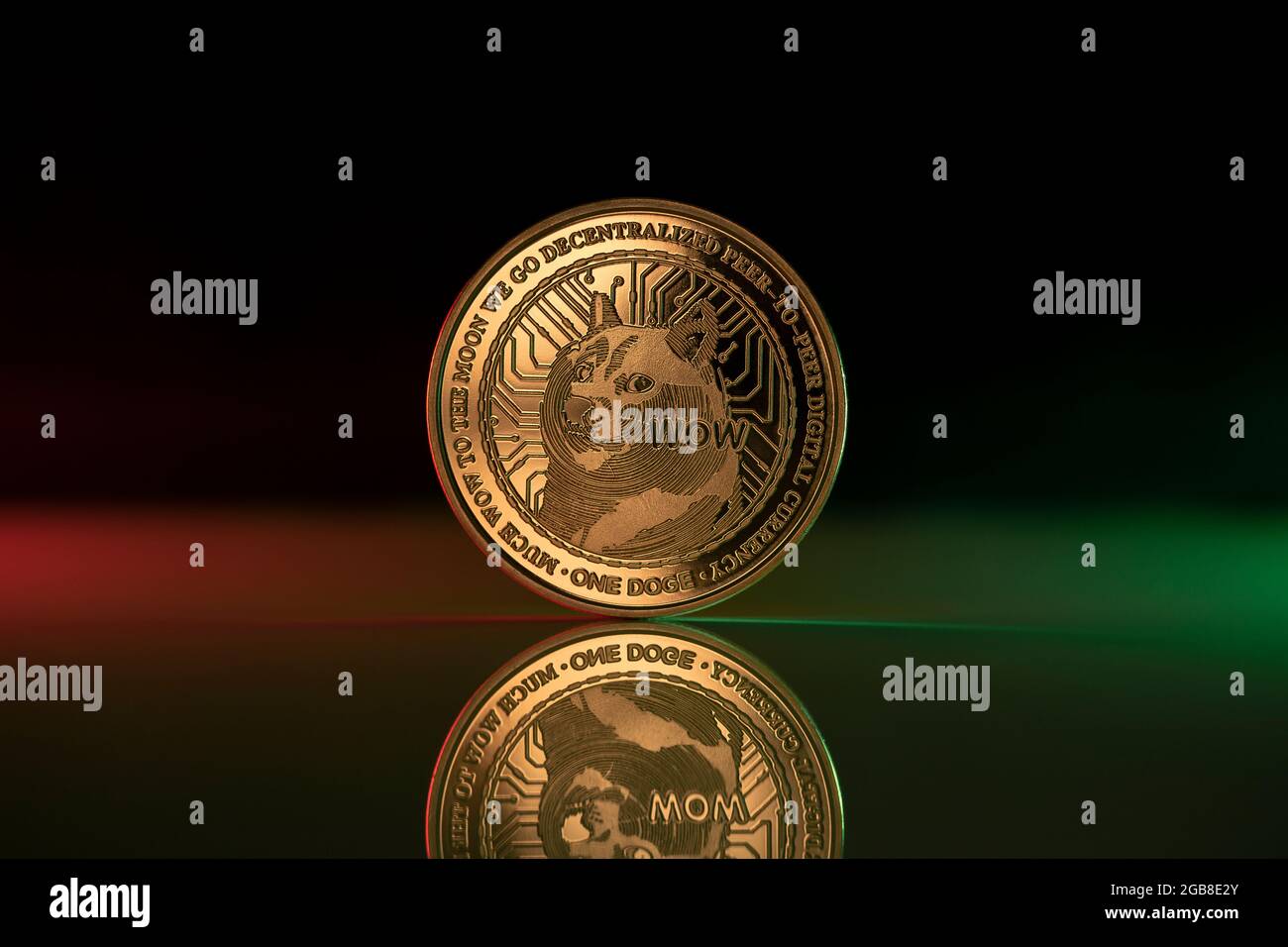 Doge cryptocurrency physical coin placed on reflective surface and lit with green and red lights Stock Photo