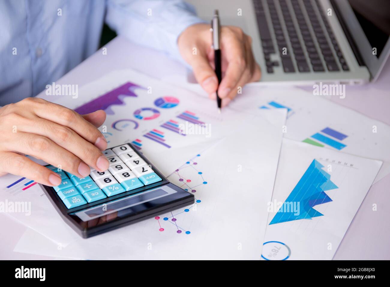 Hands of businessman calculate tax with calculator while laptop ...