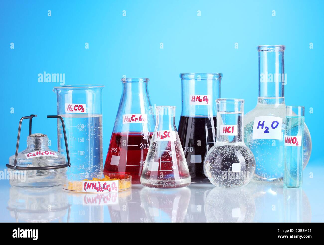 Test-tubes with various acids and chemicals on blue background Stock ...