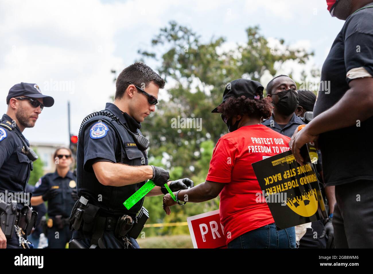Washington, DC, USA, 2 August 2021.  Pictured: Capitol Police officer A. Bryant arrests a Moral Monday March protester during a civil disobedience action on Constitution Avenue,  The march was sponsored by the Poor People’s Campaign, Kairos Center, and Repairers of the Breach.  Credit: Allison Bailey / Alamy Live News Stock Photo