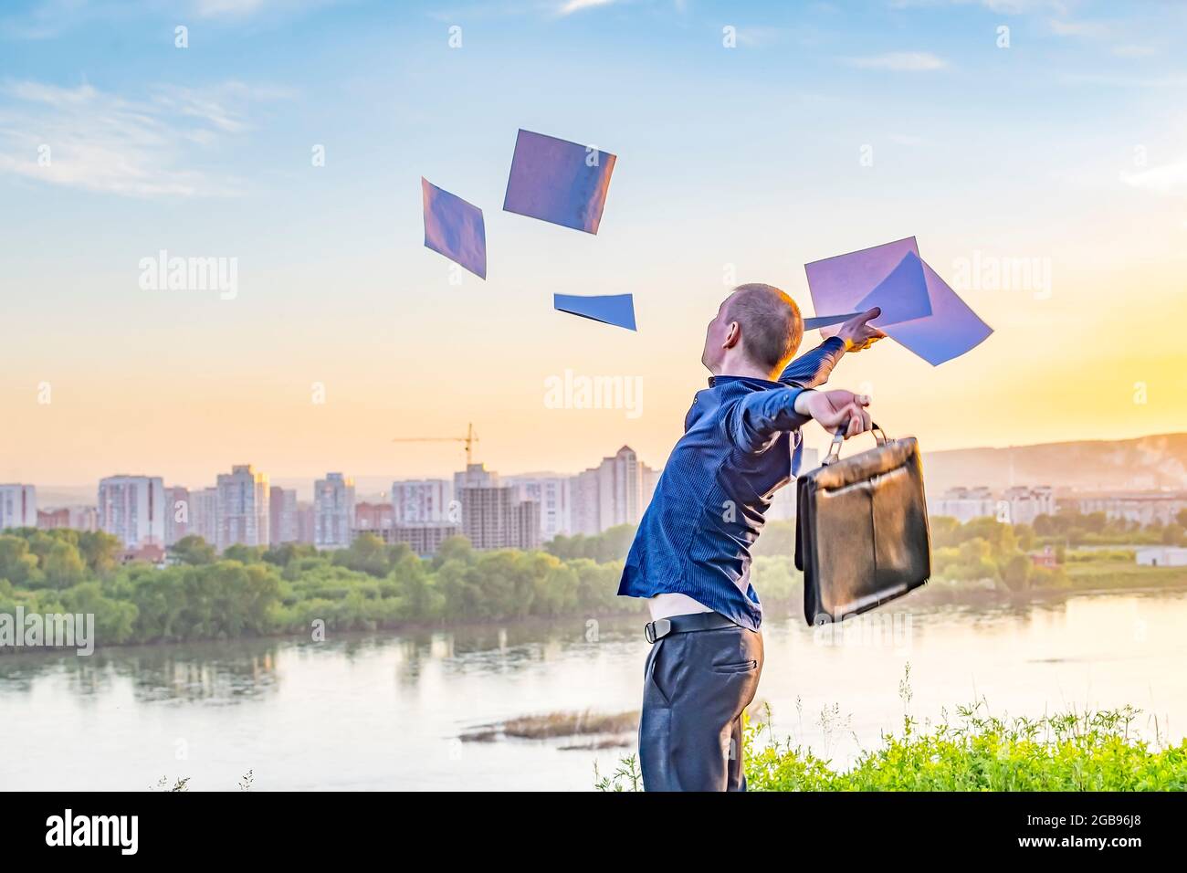person, a man, a businessman throws documents, papers up in the air with joy as a sign of repayment of the loan, getting rid of debt obligations Stock Photo