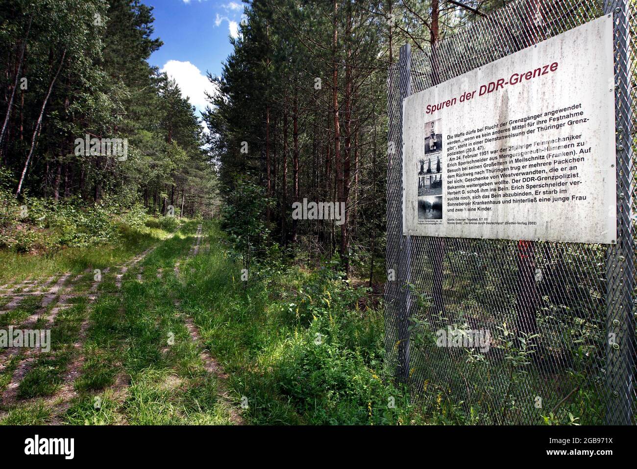 Border fence, expanded metal fence, border signal fence with memorial plaque Traces of GDR history, column trail, hiking trail through woodland in Stock Photo