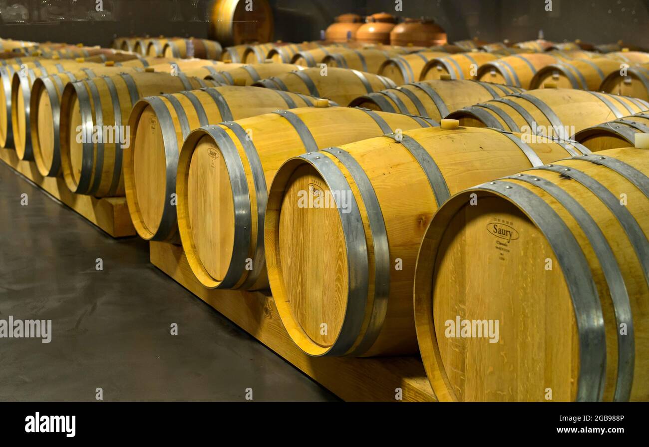 Saury oak barrels with Heida wine in the barrique cellar of the St. Jodern Winery, Visperterminen, Valais, Switzerland Stock Photo