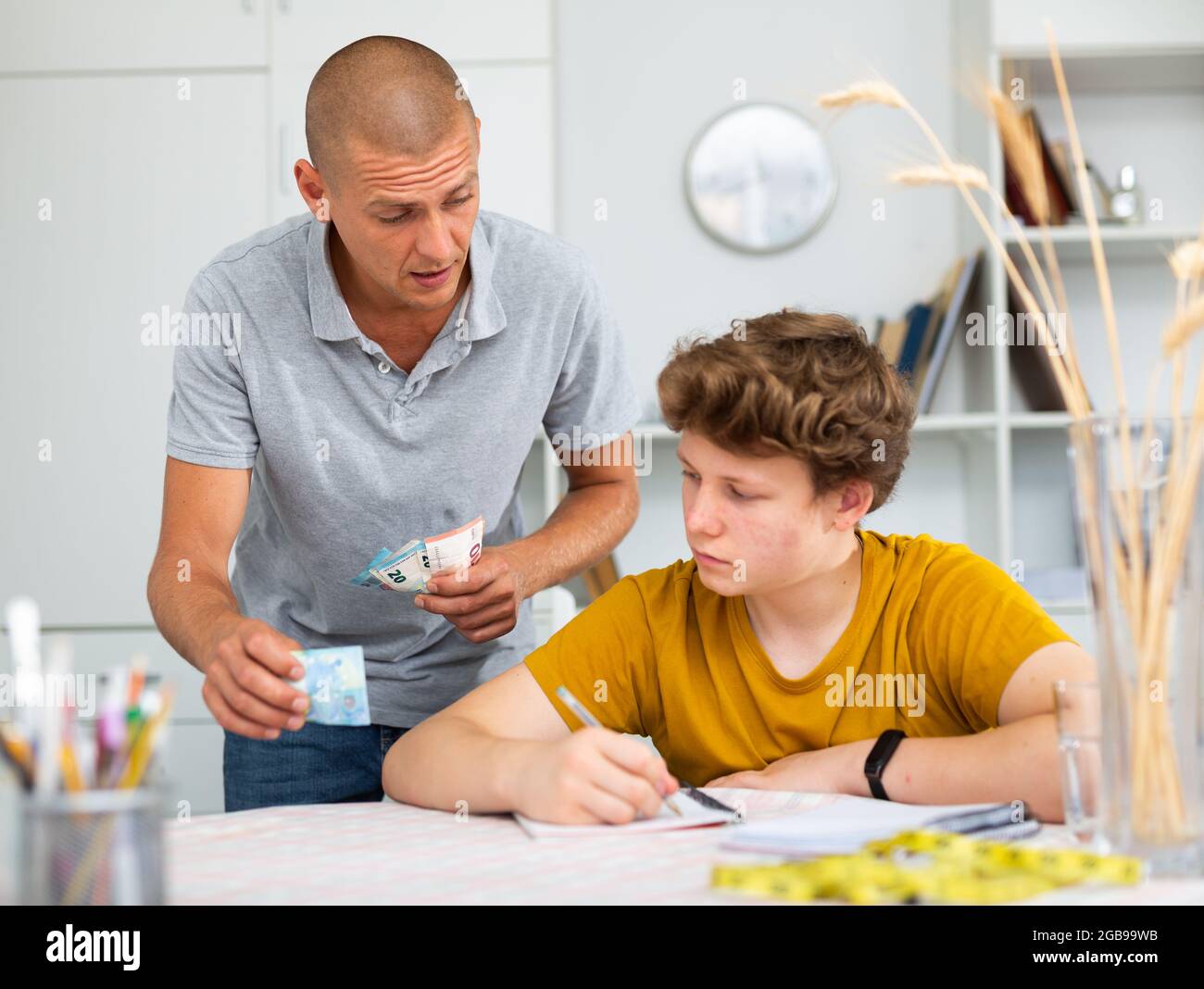 Father giving son money Stock Photo - Alamy