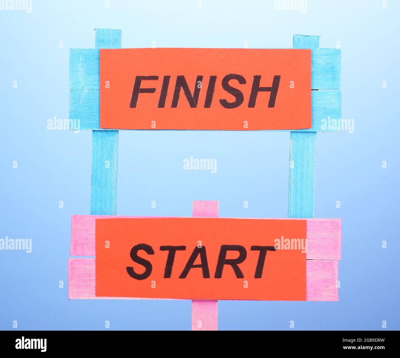 Start, finish wooden boards on blue background Stock Photo - Alamy
