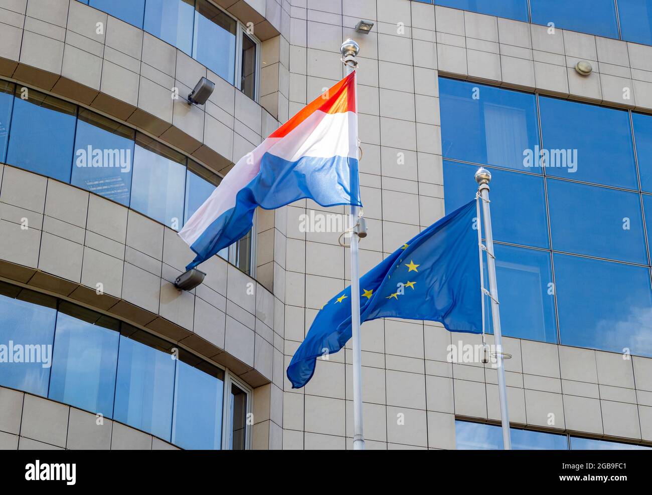 Flags of the Netherlands and European Union on flagpole waving during