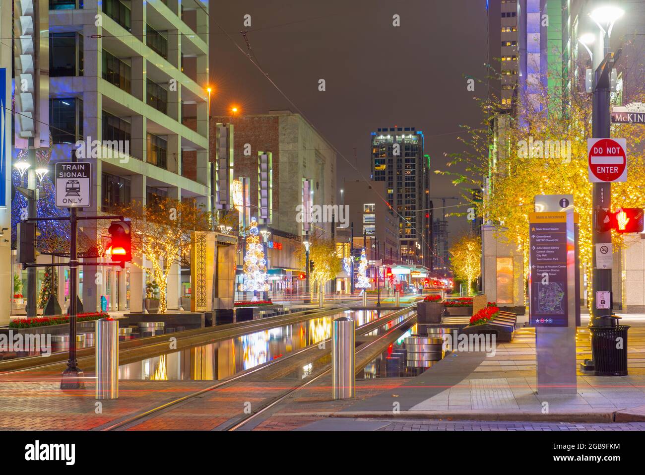 Houston downtown night scene on Main Street at McKinney Street with the METRORail rails in city