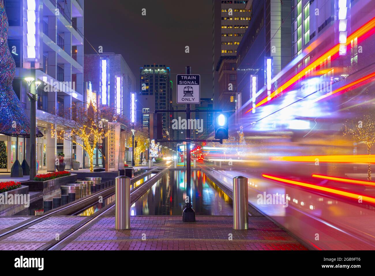 Houston downtown night scene on Main Street at McKinney Street with the METRORail rails in city