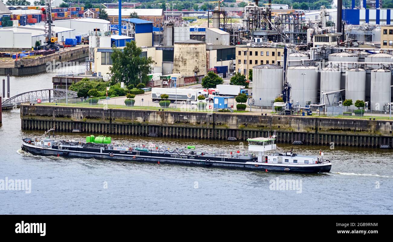 Hamburg, Germany, July 22, 2021: Flat tanker for inland canal transport sails in front of the quay wall of the oil port on the river Elbe Stock Photo