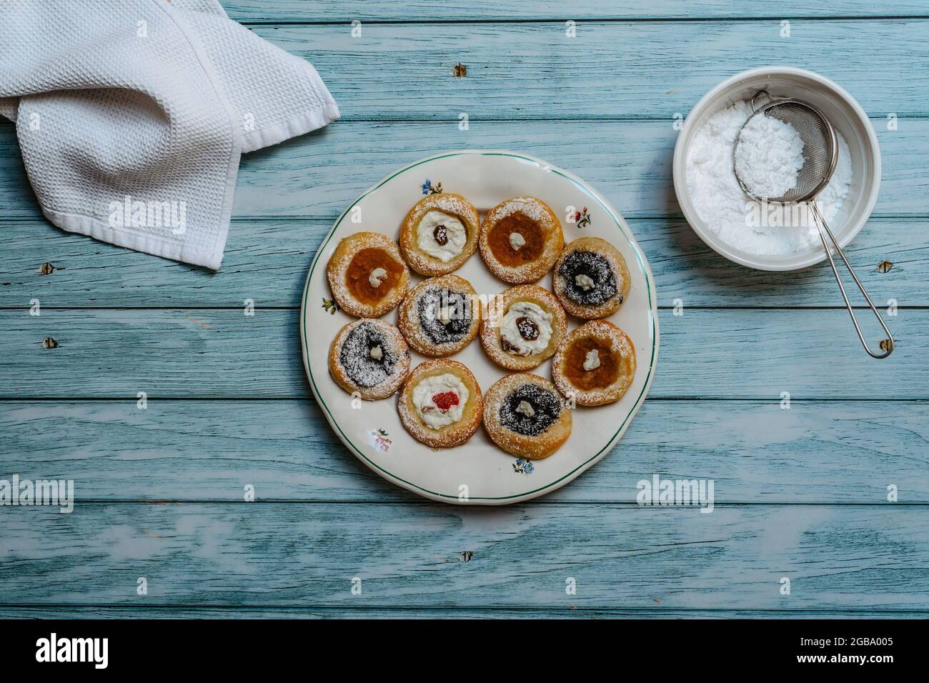 Rustic plate with freshly homemade pie stuffed with cream cheese, jam, poppy.Cookies ready to eat on blue wooden table.Delicious traditional Czech Stock Photo