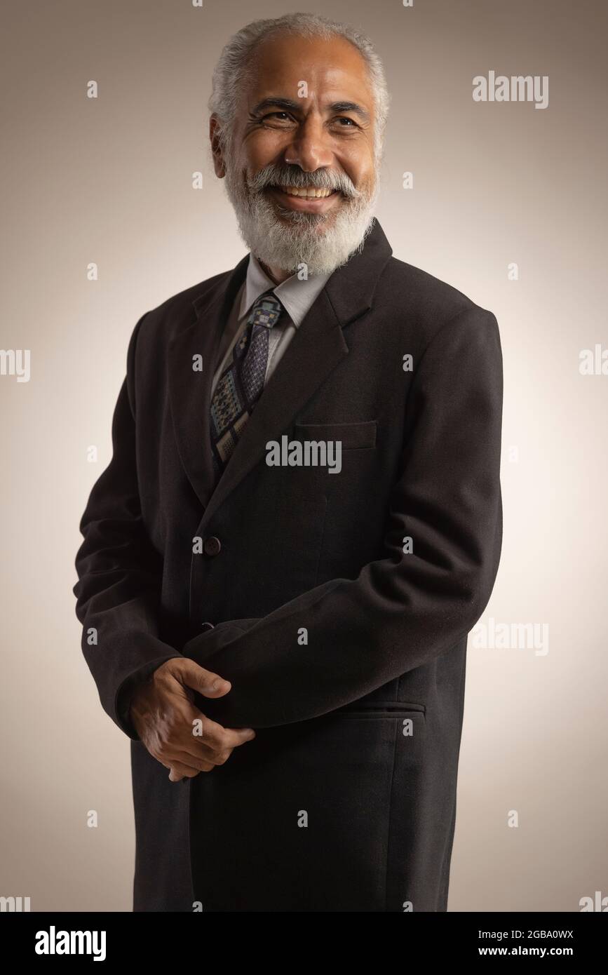 A HAPPY OLD MAN WEARING FORMALS LOOKING AWAY AND SMILING Stock Photo