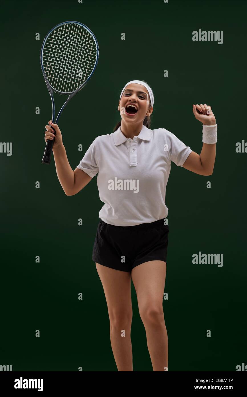 A WOMAN TENNIS PLAYER HAPPILY CHEERING Stock Photo
