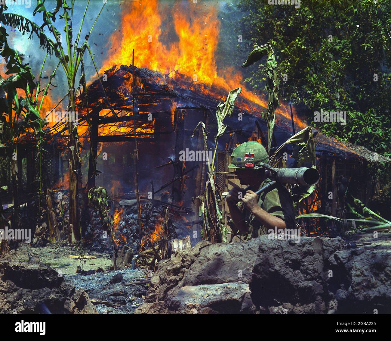 MY THO, VIETNAM - 05 April 1968 - My Tho, Vietnam. A Viet Cong base camp being burned. In the foreground is Private First Class Raymond Rumpa from St Stock Photo