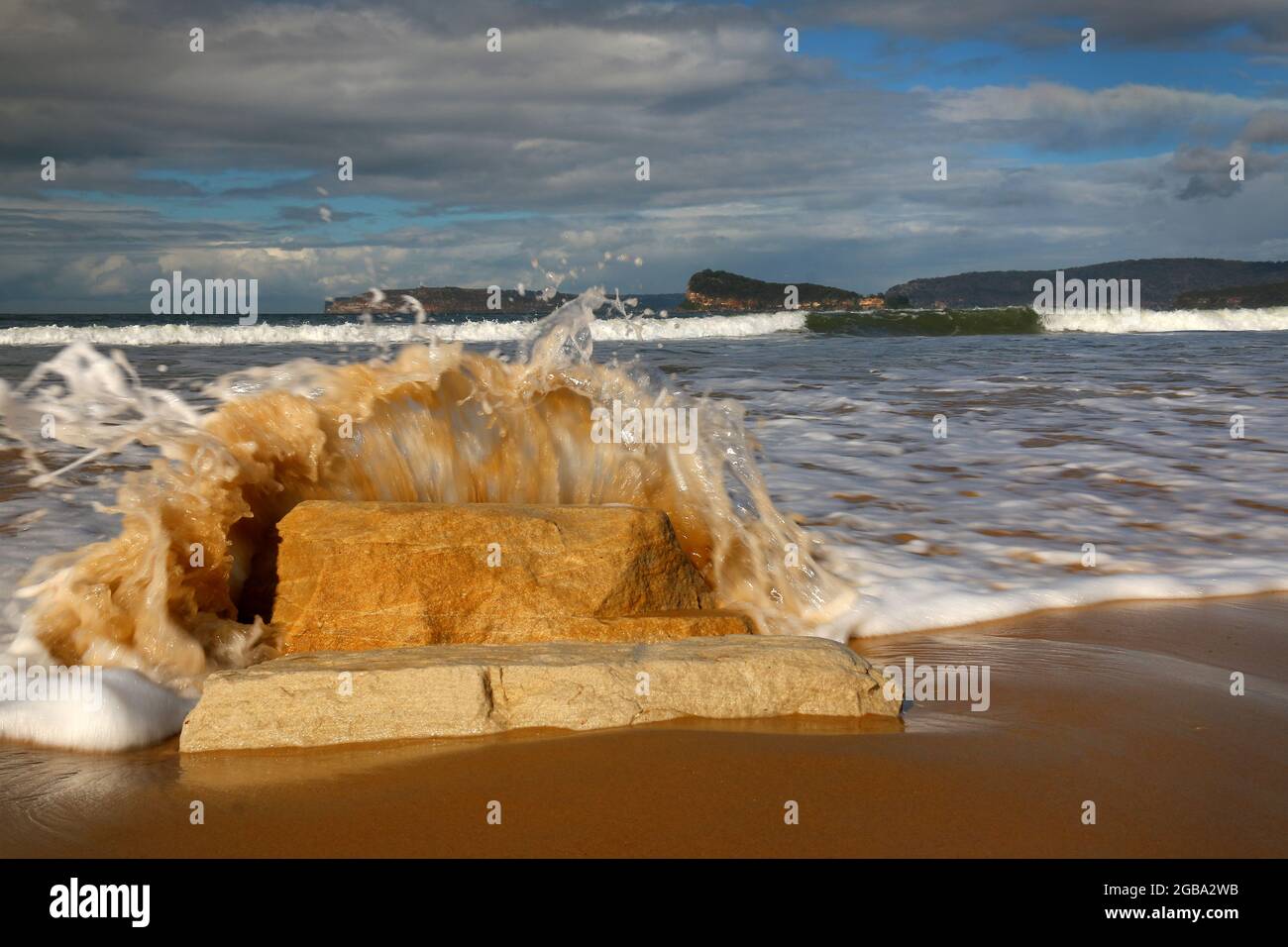 water splashing onto rocks at the beach Stock Photo