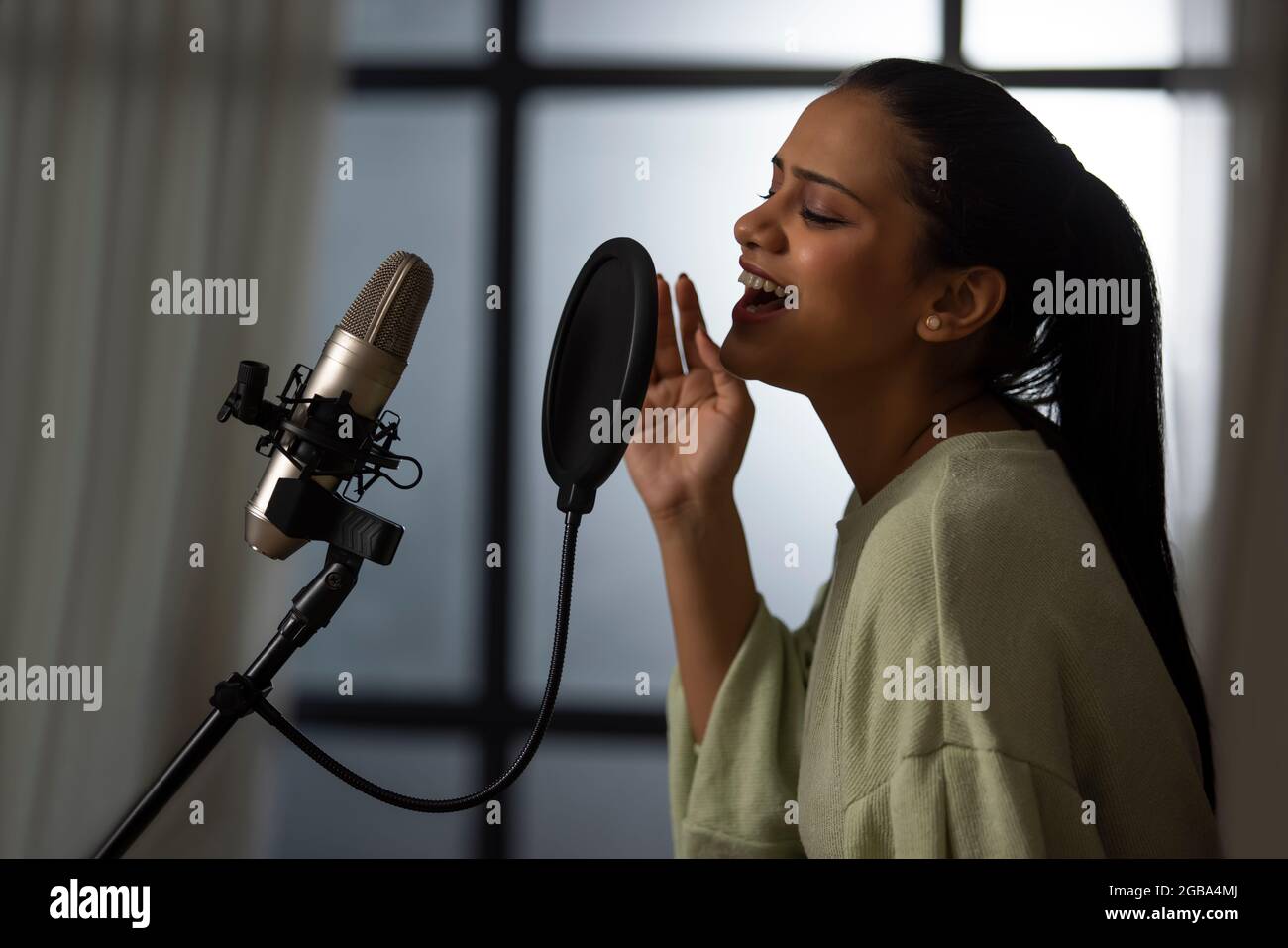 A PROFESSIONAL SINGER HAPPILY RECORDING MUSIC ON MICROPHONE Stock Photo ...