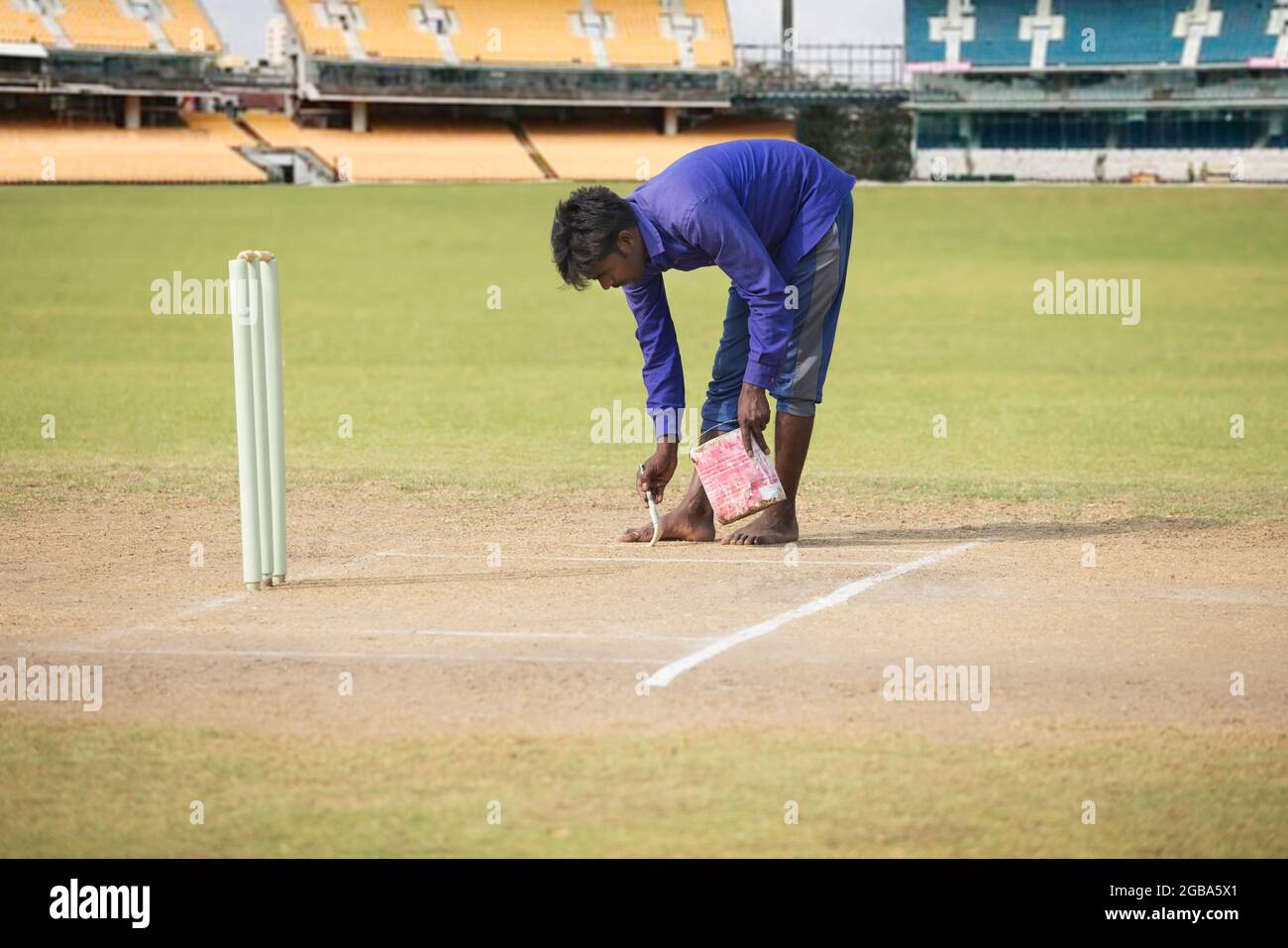Groundsman making the crease before a match Stock Photo