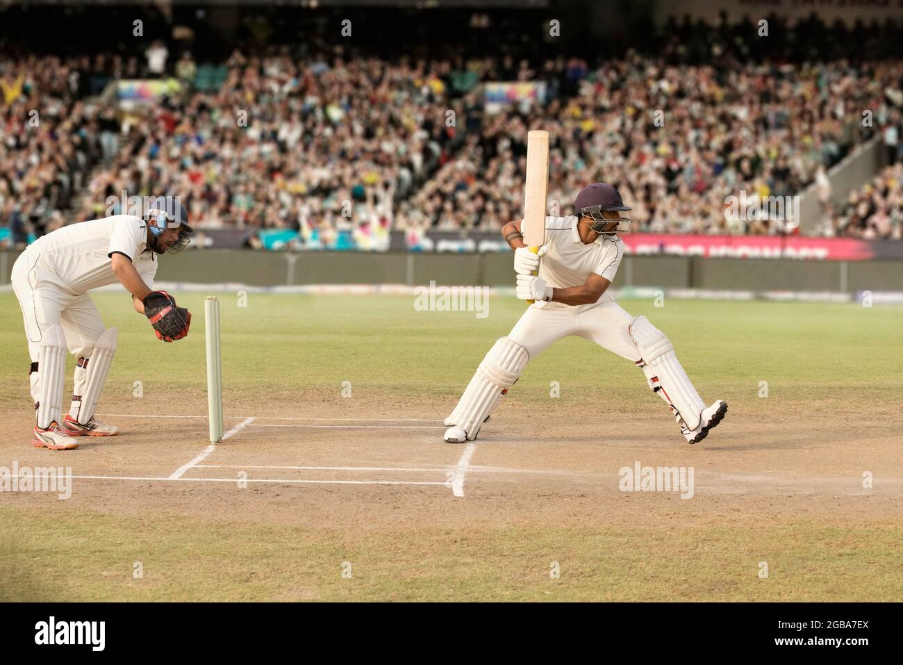 Cricketer, batsman hitting a shot at the crease during a match Stock