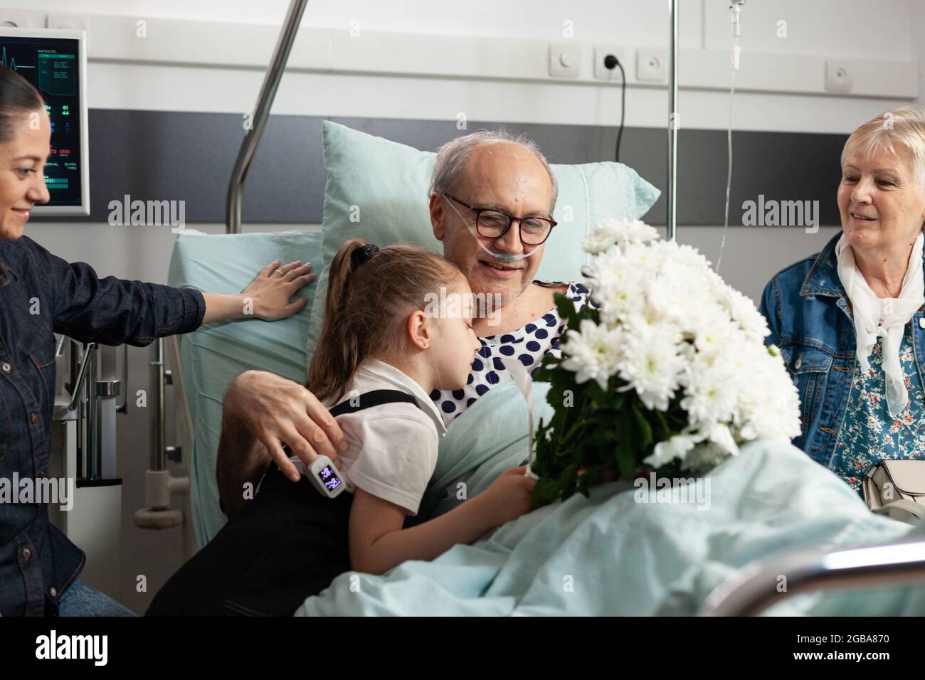 Little child visiting sick elderly grandfather supporting him after