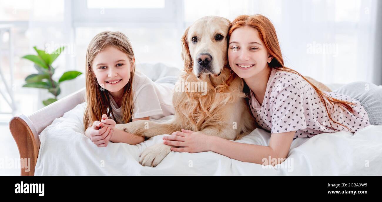 Girls with golden retriever dog in the bed Stock Photo - Alamy