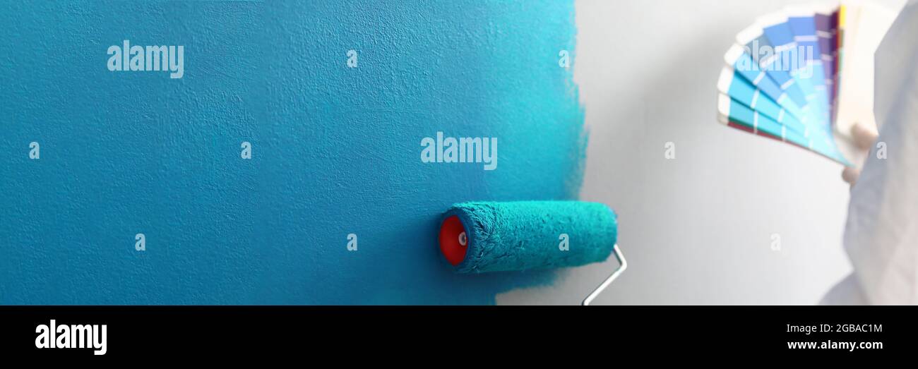 Master painter holds in his hands color palette with shades of blue