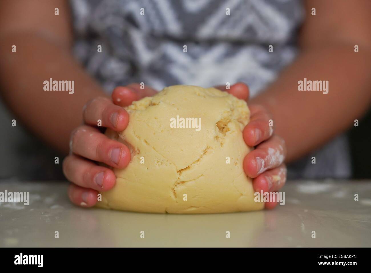 Girl hands cooks cookie dough. She mixes butter, powdered sugar and