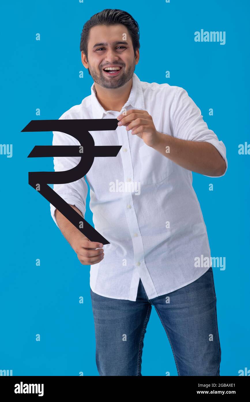 A young man holding Indian rupee symbol made of cardboard in hand Stock ...