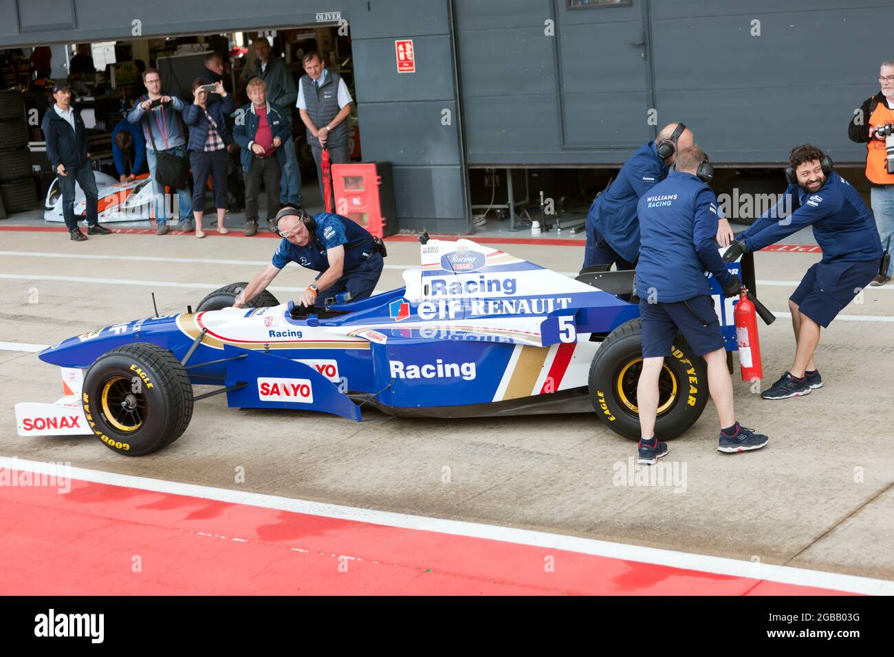 Members of the Williams Racing Team, returning Damon Hills  Championship Winning, Williams FW18 Formula One Car to the pit garage at Silverstone Stock Photo