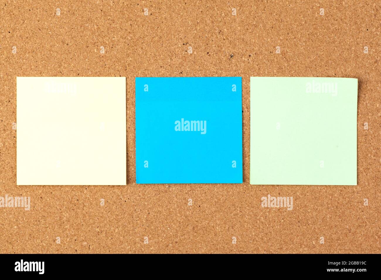 Cork board with several colorful blank notes with pins Stock Photo