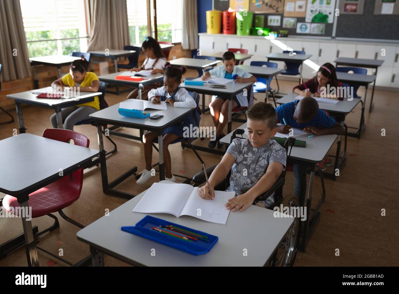 Group of diverse students studying while sitting on their desk in the class at school Stock Photo