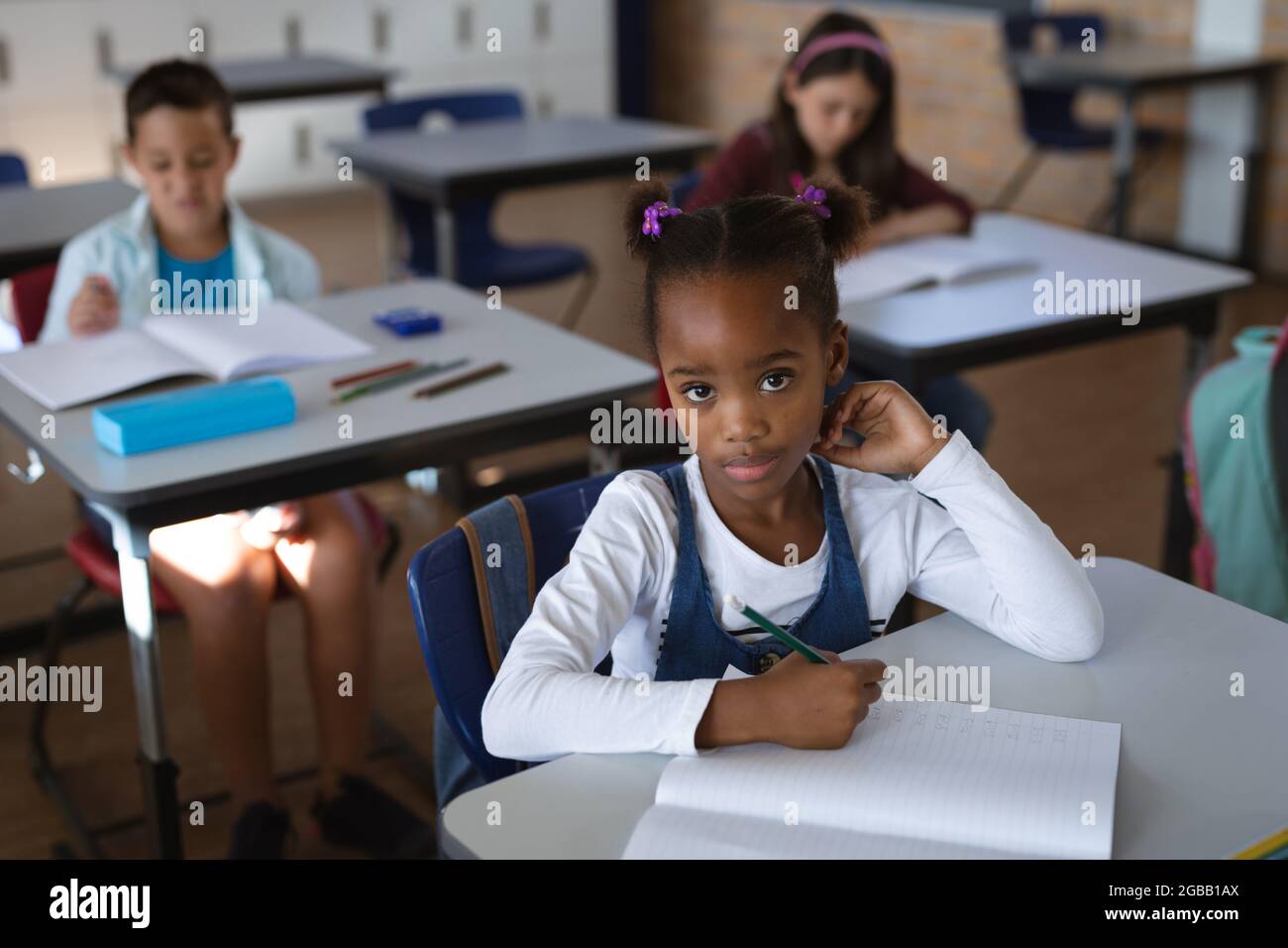Portrait of african american girl sitting on her desk in the class at ...