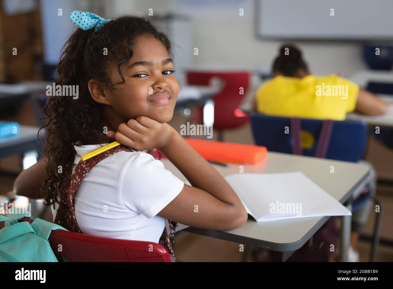 Portrait of african american girl sitting on her desk in the class at ...