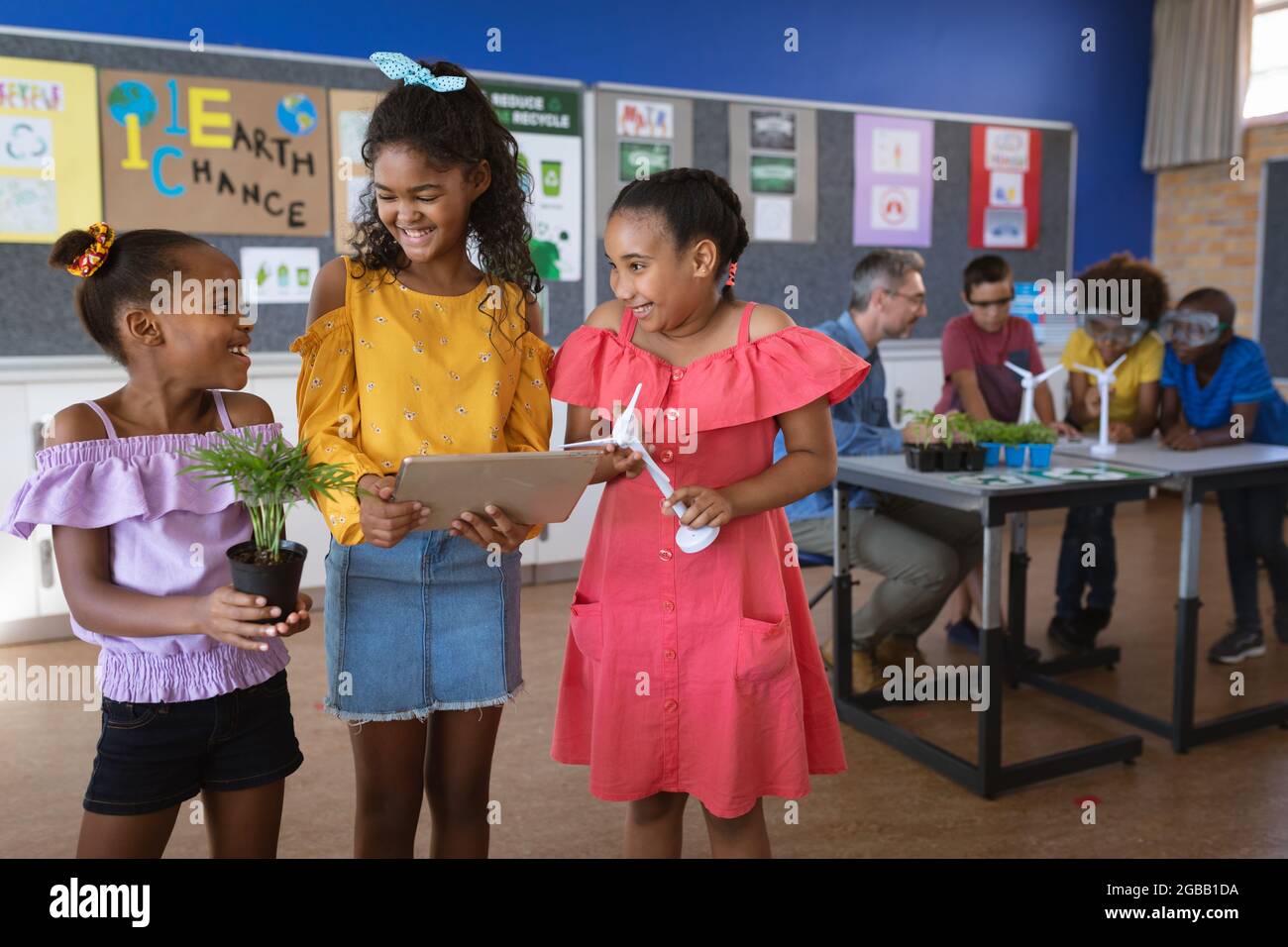 Three african american girls smiling looking at each other in environment class at school Stock Photo