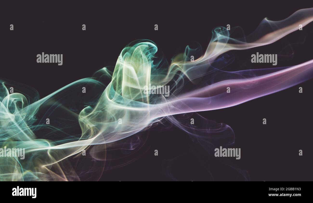 Cloud of rainbow color smoke line on dark grey backdrop close up view Stock Photo