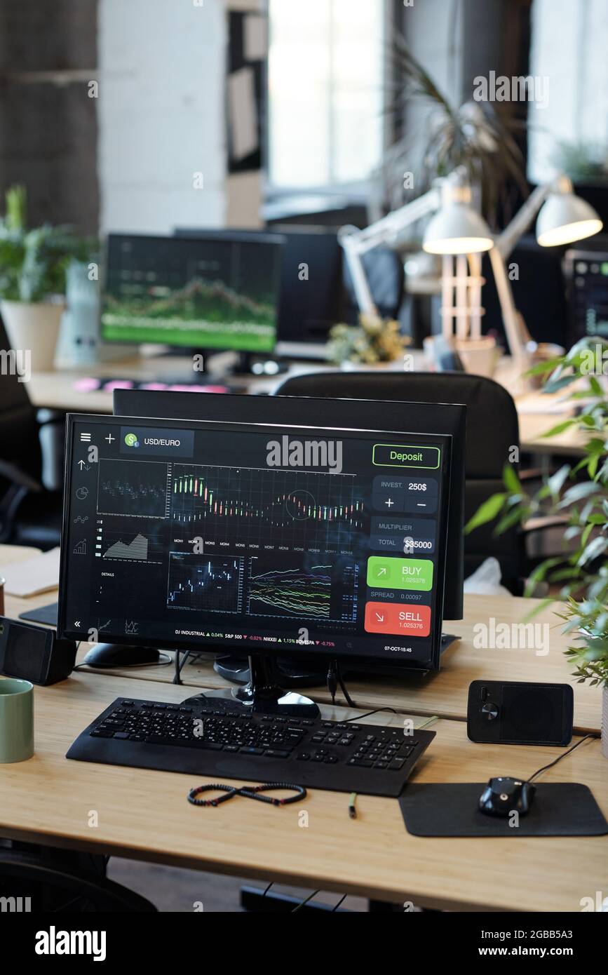 Computer monitor with graphic online information standing on desk Stock
