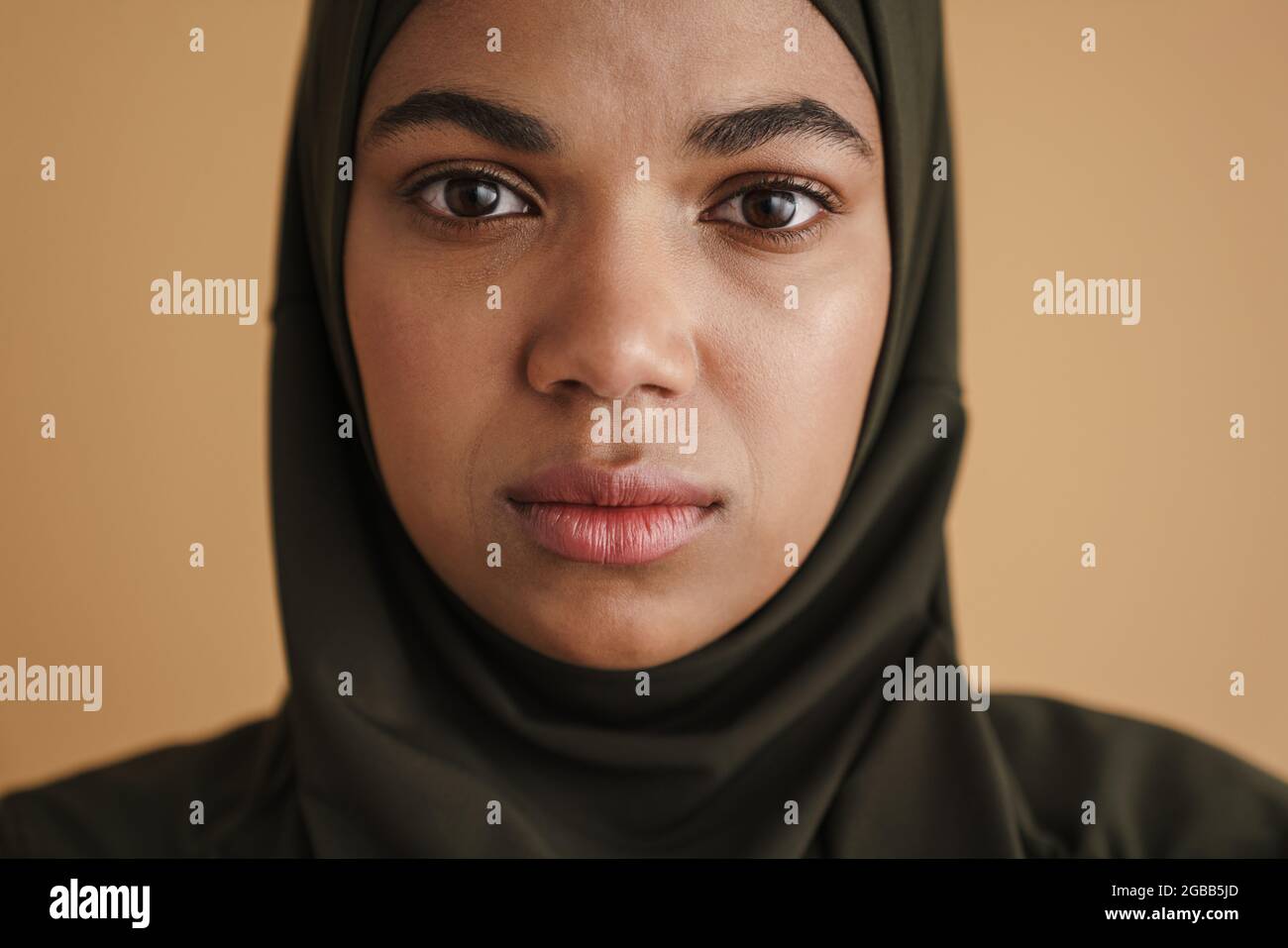 Black muslim woman in hijab posing and looking at camera isolated over ...