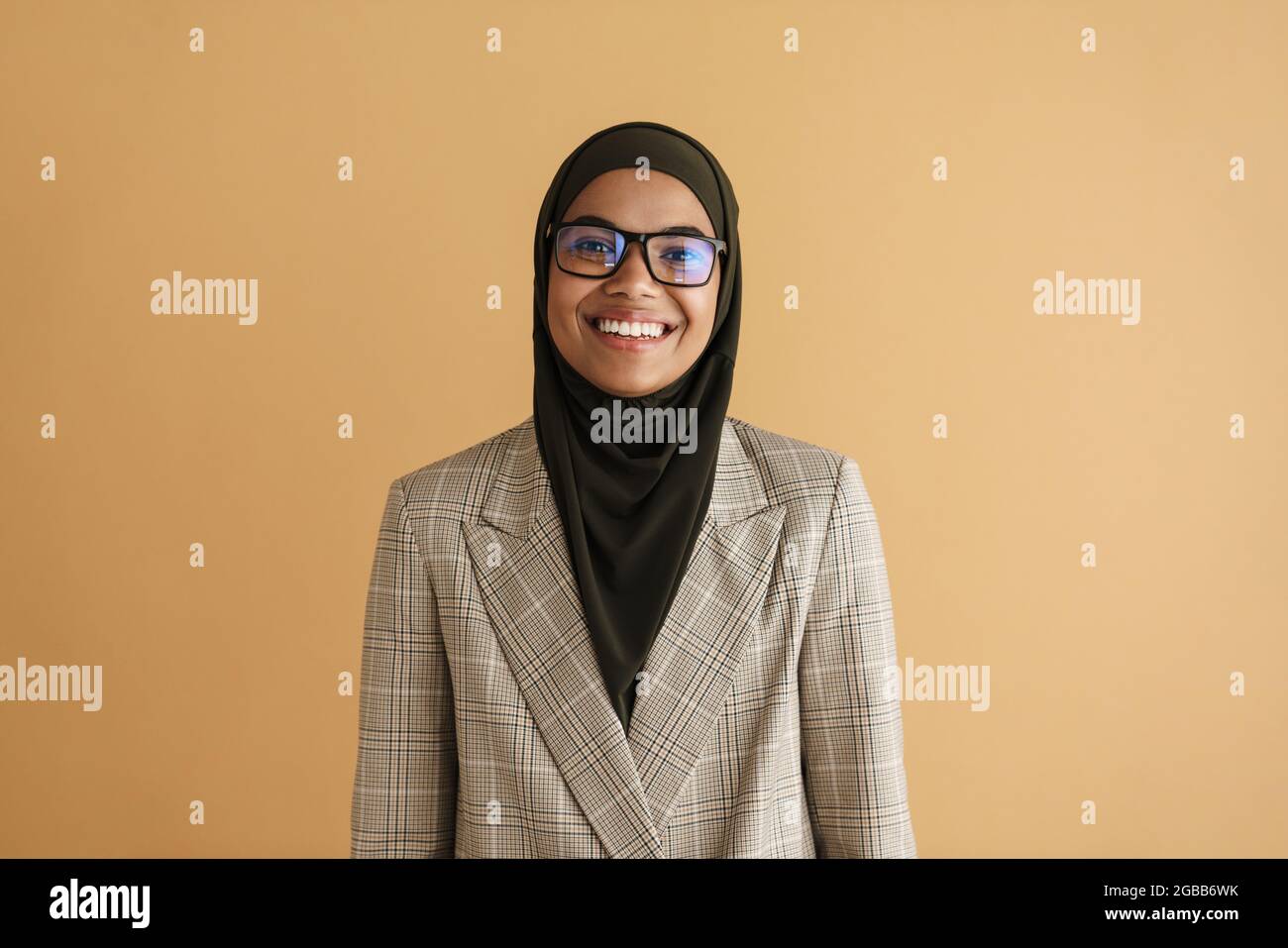 Black muslim woman in hijab smiling while posing at camera isolated ...