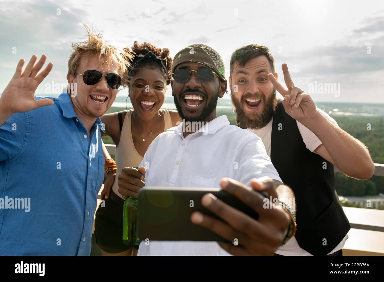 Young cheerful intercultural friends making selfie outdoors Stock Photo