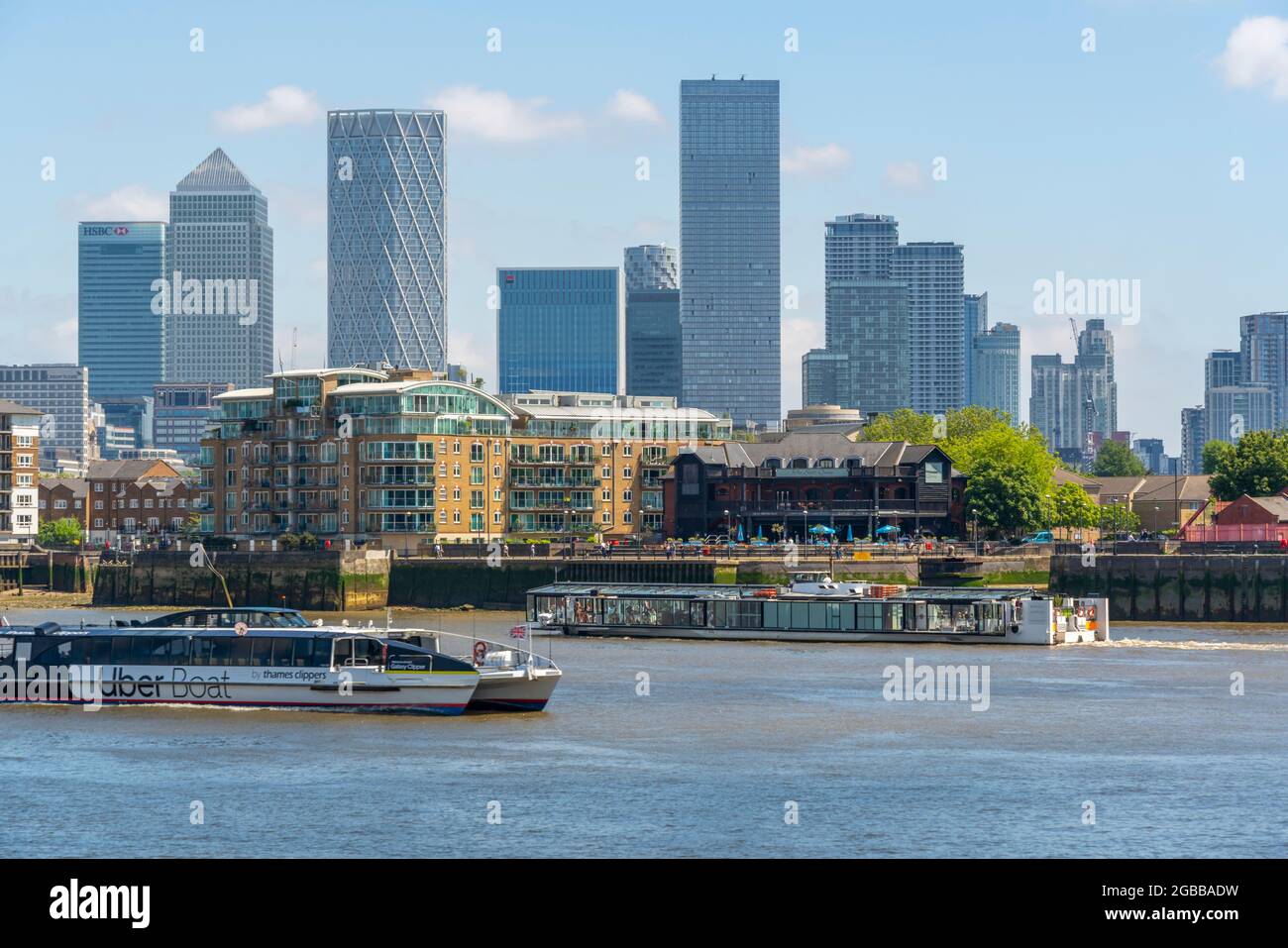 View of Canary Wharf Financial District and taxi boat from the Thames Path, London, England, United Kingdom, Europe Stock Photo
