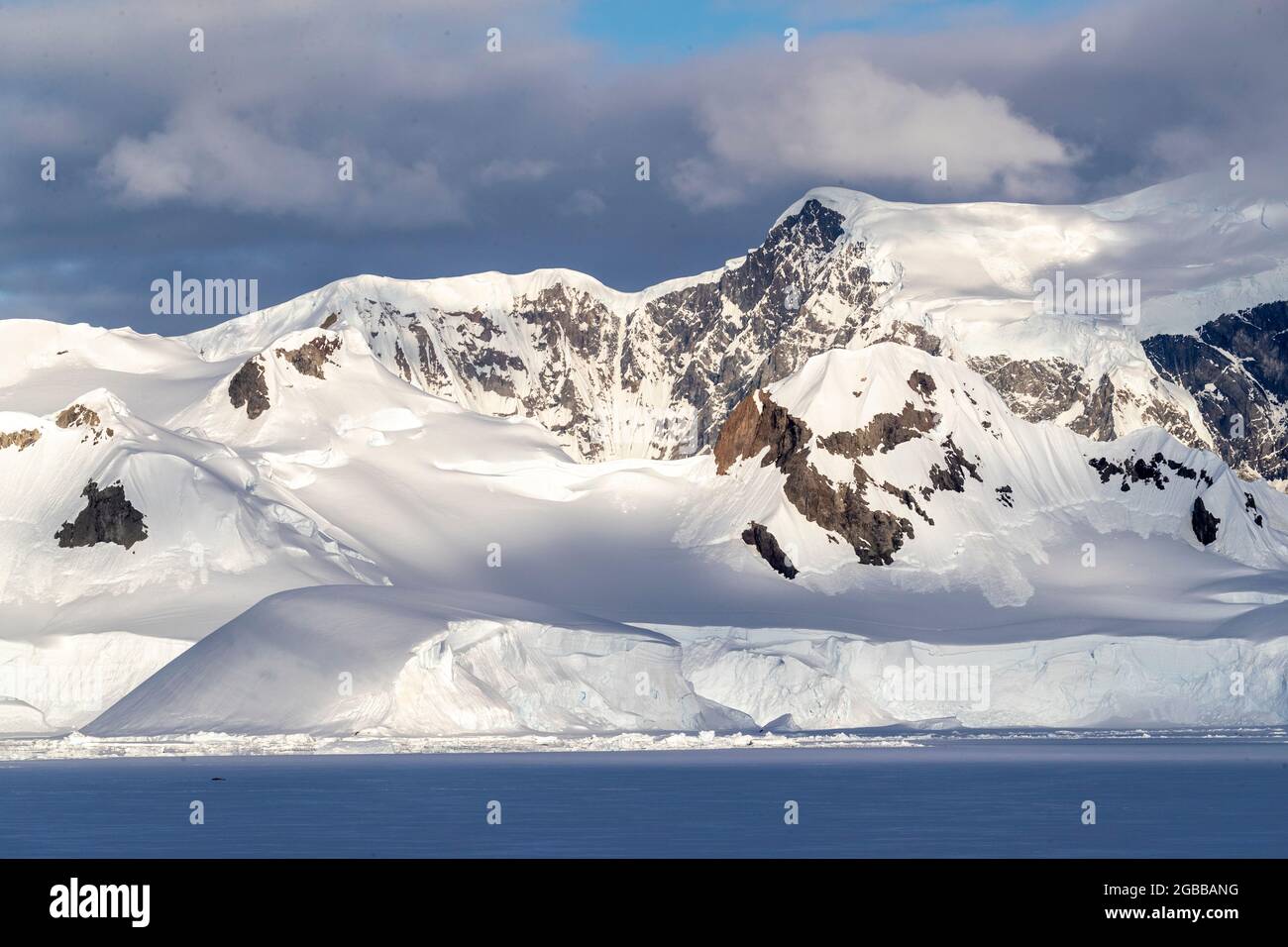 Shorefast ice and snow covered mountains in early season in Wilhamena Bay, Antarctica, Polar Regions Stock Photo