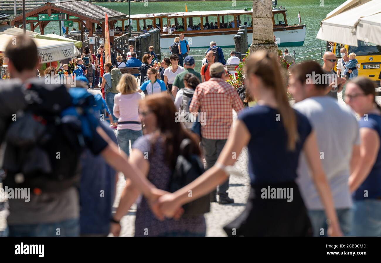 03 August 2021, Bavaria, Berchtesgaden: Tourists walk down a road to the Königssee. In the holiday region of Berchtesgadener Land, more corona rules apply again due to increased incidence Photo: Peter Kneffel/dpa Stock Photo
