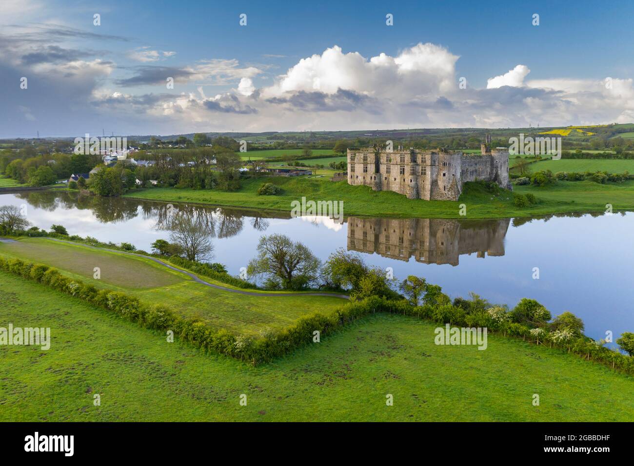 Carew Castle reflected in the mill pond on a still spring morning, Pembrokeshire Coast National Park, Wales, United Kingdom, Europe Stock Photo