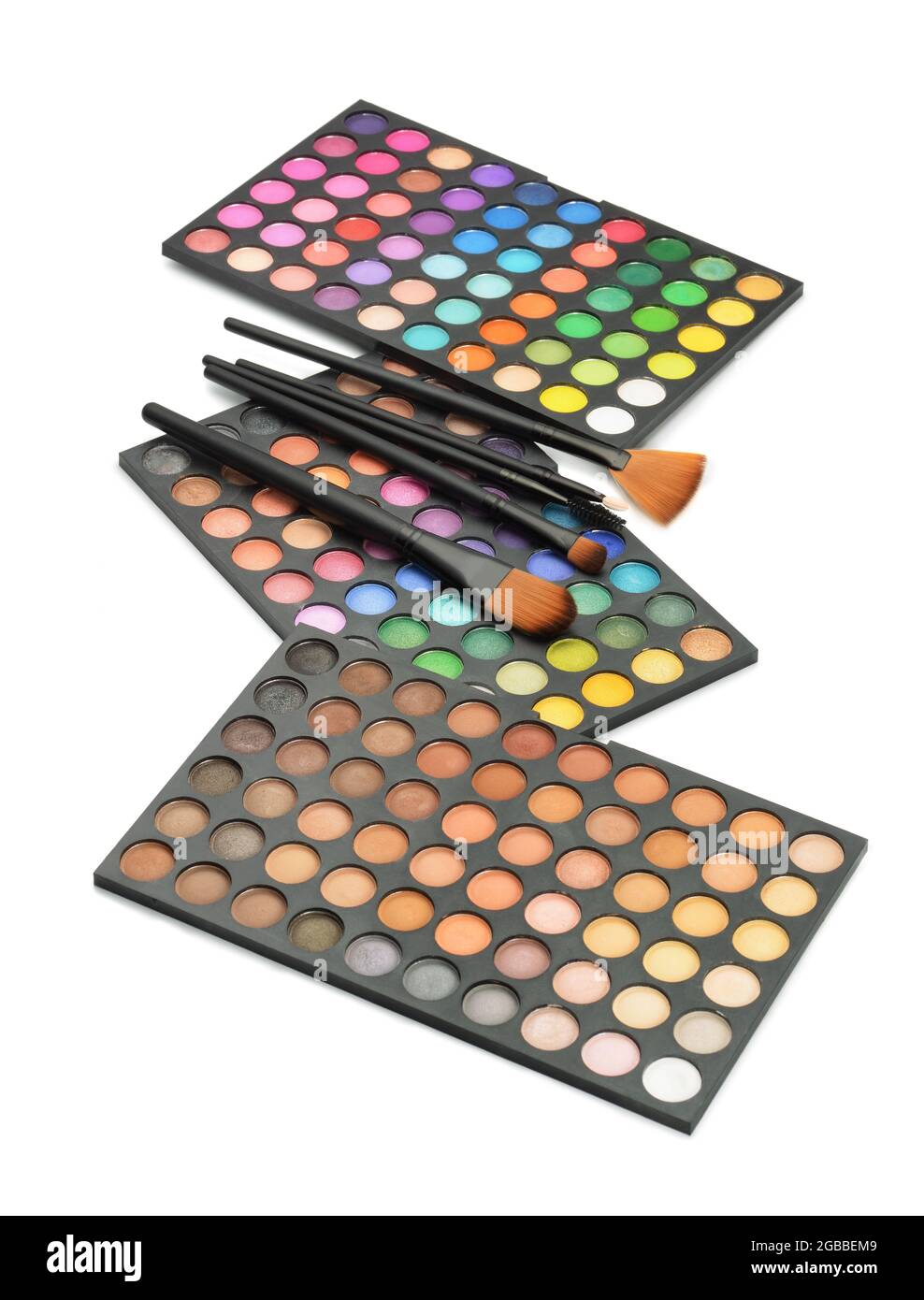 Three professional makeup shade palettes and makeup brushes isolated on white Stock Photo