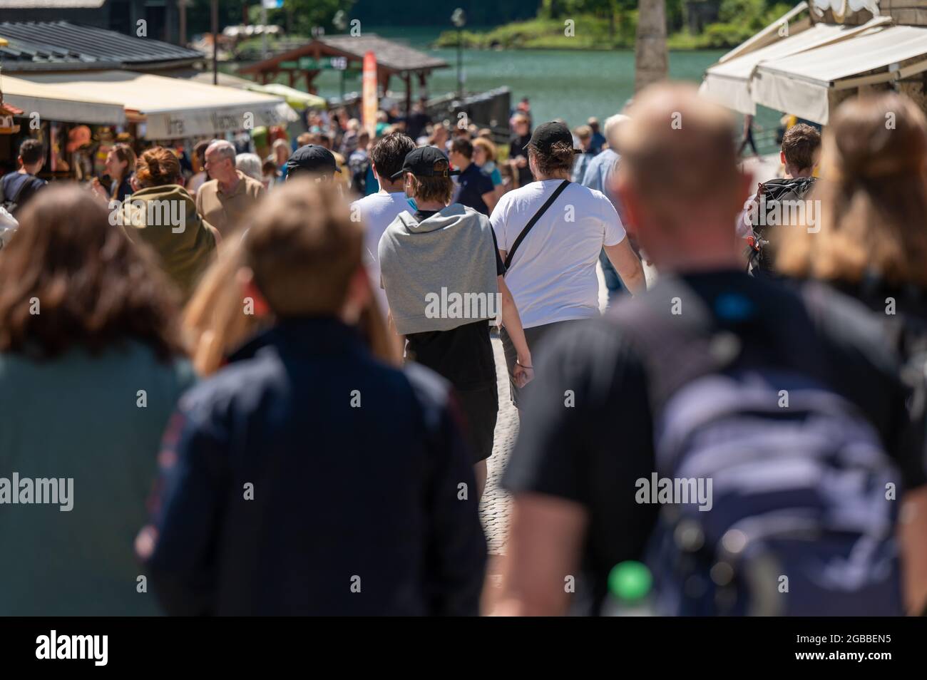 Berchtesgaden, Germany. 03rd Aug, 2021. Tourists walk down a road to the Königssee. In the holiday region of Berchtesgadener Land, more corona rules apply again due to increased incidence. Credit: Peter Kneffel/dpa/Alamy Live News Stock Photo