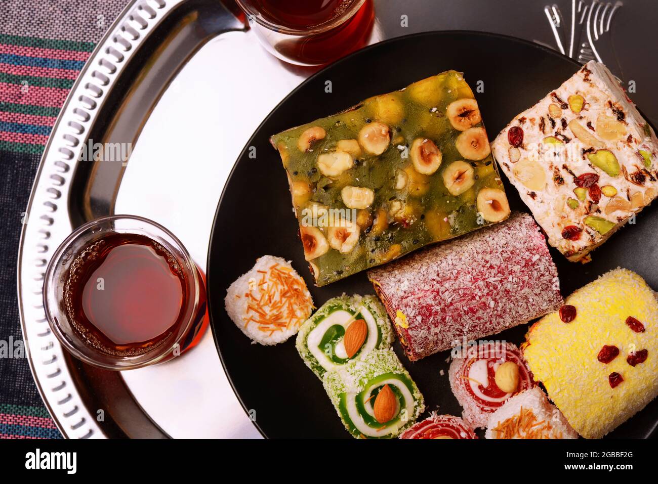 Top view of various traditional turkish delights with nuts and tea glasses Stock Photo
